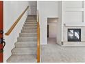 Bright entryway with carpeted staircase and fireplace at 6415 Trailhead Rd, Highlands Ranch, CO 80130