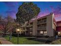 Exterior view of a condo building with multiple balconies and a large tree in the foreground at 14740 E Kentucky Dr # 725, Aurora, CO 80012