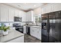 Modern kitchen with stainless steel appliances, white cabinets, and ample counter space at 19247 E Gunnison Pl # 104, Aurora, CO 80017