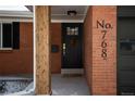 Inviting front entrance with a modern black door, brick facade and updated hardware and house numbers at 768 W Larigo Ave, Littleton, CO 80120