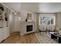 Bright living room features a stone fireplace, hardwood floors, and large windows that provide natural light at 768 W Larigo Ave, Littleton, CO 80120