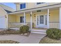 Charming covered front porch with swing and seating area, complemented by attractive landscaping and lighting at 7440 W 94Th Pl, Westminster, CO 80021