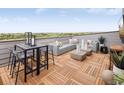 Relaxing rooftop terrace with sectional seating, outdoor dining, wood-look flooring, and expansive views at 10880 E Hinsdale Cir, Centennial, CO 80112