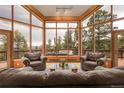 Cozy living room with floor-to-ceiling windows showcasing a stunning mountain view at 29266 S Sunset Trl, Conifer, CO 80433