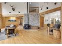 Spacious living room with wood floors, stone fireplace, and vaulted ceilings create a rustic, lodge-like ambiance at 29266 S Sunset Trl, Conifer, CO 80433