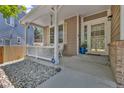 Inviting covered front porch with a white picket fence and decorative rock landscaping at 2938 S Zeno Way, Aurora, CO 80013