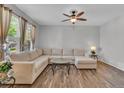 Bright living room with modern ceiling fan, neutral sofa, and hardwood flooring at 9758 Laredo St # 35B, Commerce City, CO 80022