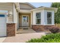 Welcoming front entrance features a brick facade, decorative window, and covered porch at 4495 Windmill Dr, Brighton, CO 80601