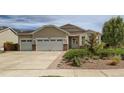 Attractive single-Gathering home with beige siding, a two-car garage, and a well-maintained lawn at 4495 Windmill Dr, Brighton, CO 80601