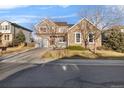 Charming two-story home with a stone facade and gray siding under a clear blue sky at 13694 Cherry St, Thornton, CO 80602