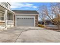 Attached two-car garage featuring stone accents and gray paint at 13694 Cherry St, Thornton, CO 80602