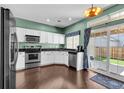 Bright kitchen with white cabinets, stainless steel appliances, and a view to the outdoor patio at 10087 E Hawaii Pl, Aurora, CO 80247