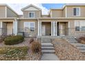 Attractive townhome exterior showcasing stone accents, siding, and a well-maintained front yard, creating a welcoming curb appeal at 9758 Laredo St # 37C, Commerce City, CO 80022