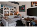 Comfortable living room with sectional sofa, playful artwork, and curated shelving at 2460 W 29Th Ave # 104, Denver, CO 80211