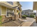 Charming townhome exterior with stone accents, walkway, and meticulous landscaping at 9569 Pearl Cir # 204, Parker, CO 80134