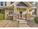Inviting front entrance with stone pillars and well-maintained landscaping at 9569 Pearl Cir # 204, Parker, CO 80134