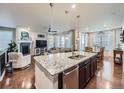 Open concept kitchen with large center island, pendant lighting, and stainless steel appliances at 18280 W 85Th Dr, Arvada, CO 80007