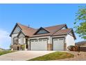 This exterior shot shows a charming home with a three-car garage, great curb appeal and a well manicured lawn at 2065 Sage Grouse Way, Castle Rock, CO 80109