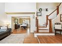 Welcoming entryway with hardwood floors, staircase, and a view into the formal dining room at 14194 W Amherst Ave, Lakewood, CO 80228