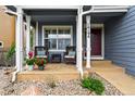 Inviting front porch with comfortable seating area, beautiful plants, and a cozy ambiance at 14194 W Amherst Ave, Lakewood, CO 80228