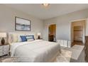Calming main bedroom with a large bed, ensuite bathroom, and neutral decor at 881 W 128Th Pl, Westminster, CO 80234