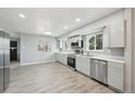 Bright, renovated kitchen featuring gray cabinets, stainless steel appliances, and wood-look flooring at 3089 S Quintero Way, Aurora, CO 80013