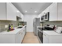 Modern kitchen with white cabinets, stainless steel appliances, and sleek countertops at 1557 S Owens St # 59, Denver, CO 80232