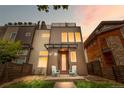 Modern home with a two-tone exterior, covered porch, and rooftop deck with sunset at 4557 Stuart St, Denver, CO 80212