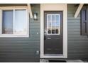 Close-up of a modern front door with sidelight and stylish exterior lighting at 3423 W Walsh Pl, Denver, CO 80219