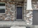Close up of front door with stone details and a covered porch at 553 Homestead Ave, Brighton, CO 80601