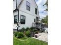 A backyard with garden beds and a patio area, framed by a white house facade with dark window trim at 1690 Spruce St, Denver, CO 80220