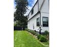 The house exterior showing white siding with black trim, a green lawn, and garden landscaping at 1690 Spruce St, Denver, CO 80220