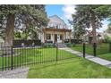 Charming home featuring a fenced yard, inviting front porch and an upper level balcony at 1690 Spruce St, Denver, CO 80220