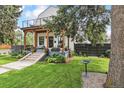Beautiful home featuring a covered porch, balcony, and lovely landscaping in the front yard at 1690 Spruce St, Denver, CO 80220
