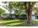Inviting home with well-maintained landscaping, blue siding, and a welcoming front yard shaded by mature trees at 11682 E Iowa Ave, Aurora, CO 80012