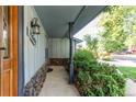 Covered porch with stone accents and fresh landscaping, offering a welcoming entrance to the home at 11682 E Iowa Ave, Aurora, CO 80012