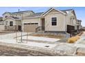 Inviting exterior view of home with a two car garage, black front door and landscaped front yard at 9693 Ceylon St, Commerce City, CO 80022