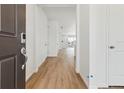 Bright hallway features hardwood floors leading to an open-concept living space at 9693 Ceylon St, Commerce City, CO 80022