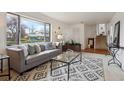 Inviting living room featuring a large window, plush sofa, patterned rug, and modern decor at 10830 Claire Ln, Northglenn, CO 80234