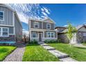 Charming two-story home with a well-manicured lawn and inviting walkway to the front door at 28428 E 8Th Pl, Watkins, CO 80137