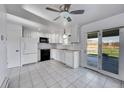 Well-lit kitchen featuring white cabinets, tile flooring, and a sliding glass door to the backyard at 1796 S Yampa Way, Aurora, CO 80017
