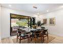 Open dining room features sleek furnishings and bi-fold doors to outdoor living space at 2140 Tabor Dr, Lakewood, CO 80215