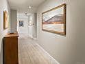 Long hallway with neutral walls, track lighting, art, tiled floor, and baseboards at 400 E 3Rd Ave # 305, Denver, CO 80203