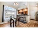 Eat-in kitchen features an oversized window, a breakfast bar, and a dining table for casual dining at 4493 Dunkirk Way, Denver, CO 80249
