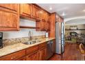 Kitchen with granite countertops, stainless steel appliances, and open view to the living room at 7891 Poplar St, Commerce City, CO 80022