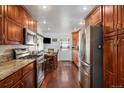 Kitchen featuring stainless steel appliances, wood cabinets, and dining area near backdoor at 7891 Poplar St, Commerce City, CO 80022