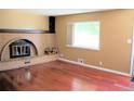 Cozy living room featuring a brick fireplace and hardwood floors at 7891 Poplar St, Commerce City, CO 80022