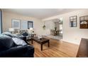 Comfortable living room showcasing hardwood floors and an open layout to the dining area at 1157 S Vivian St, Lakewood, CO 80228
