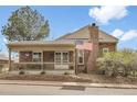 Charming brick home featuring a covered front porch and an American flag at 7291 E Bentley Cir, Centennial, CO 80122
