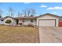 Charming single-story home featuring a well-maintained lawn, white siding and an attached two-car garage at 3175 Zinnia Ct, Golden, CO 80401